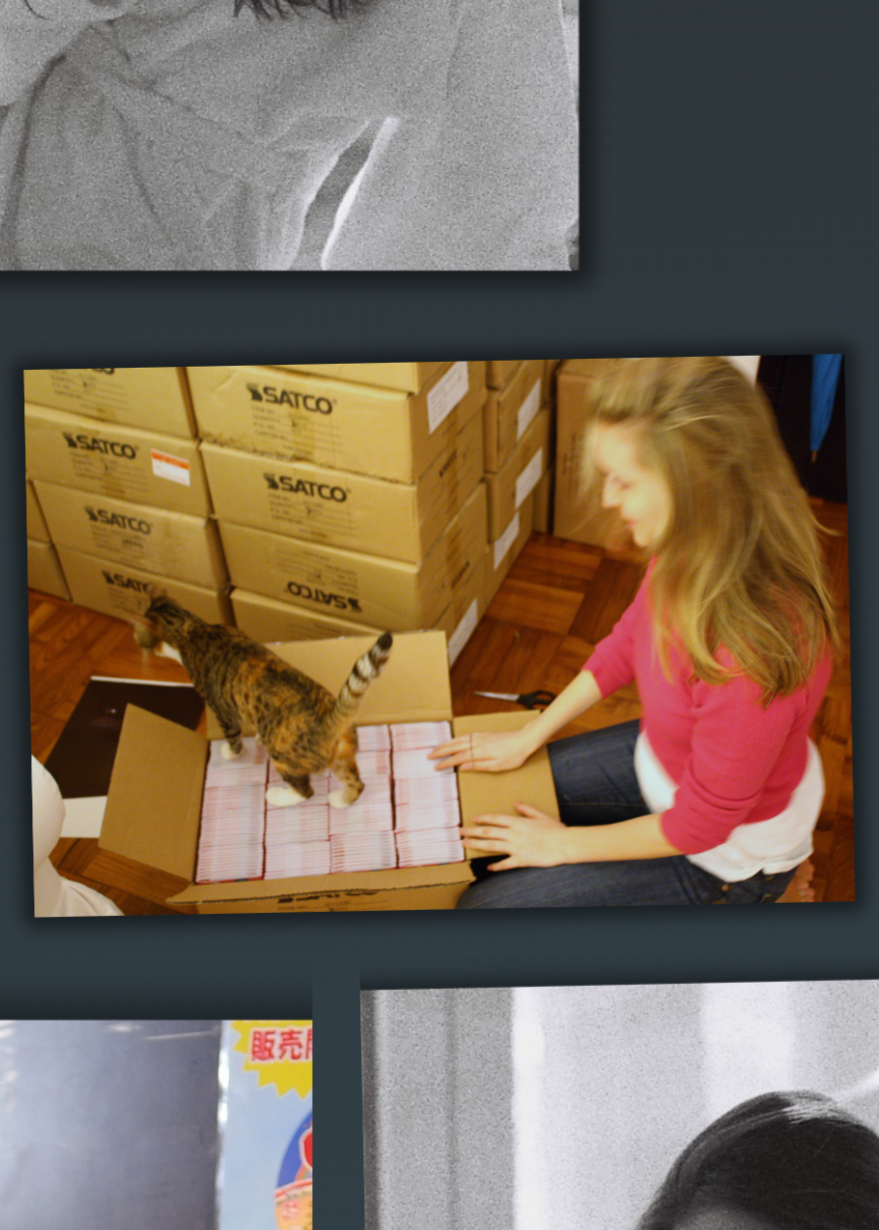 Kelly with a cat, surrounded by boxes in warm indoor light
